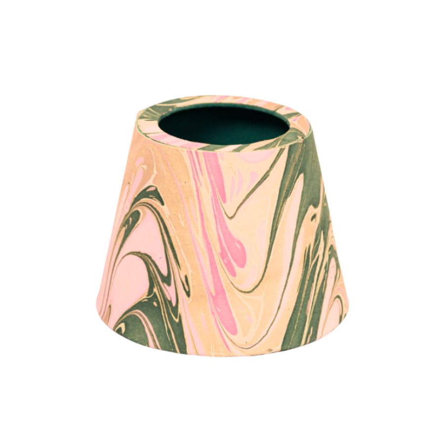 A small lampshade featuring a marbled pattern of pink, and olive green swirls, set against a plain white background.