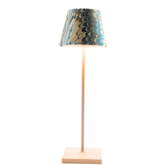 A modern table lamp with a square wooden base, a slim matching wooden stem, and a tapered fabric shade featuring a marbled pattern of blue, beige, and brown.