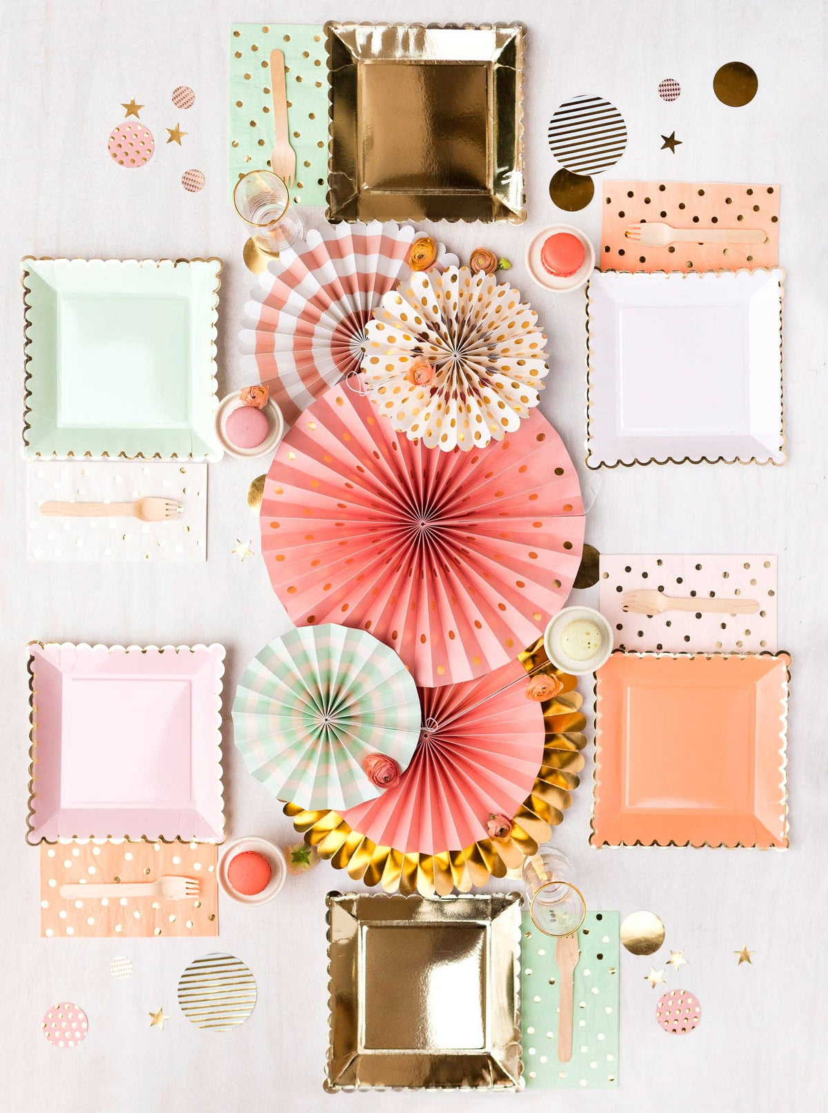 Colorful party supplies including plates, napkins, and decorative fans on a white background