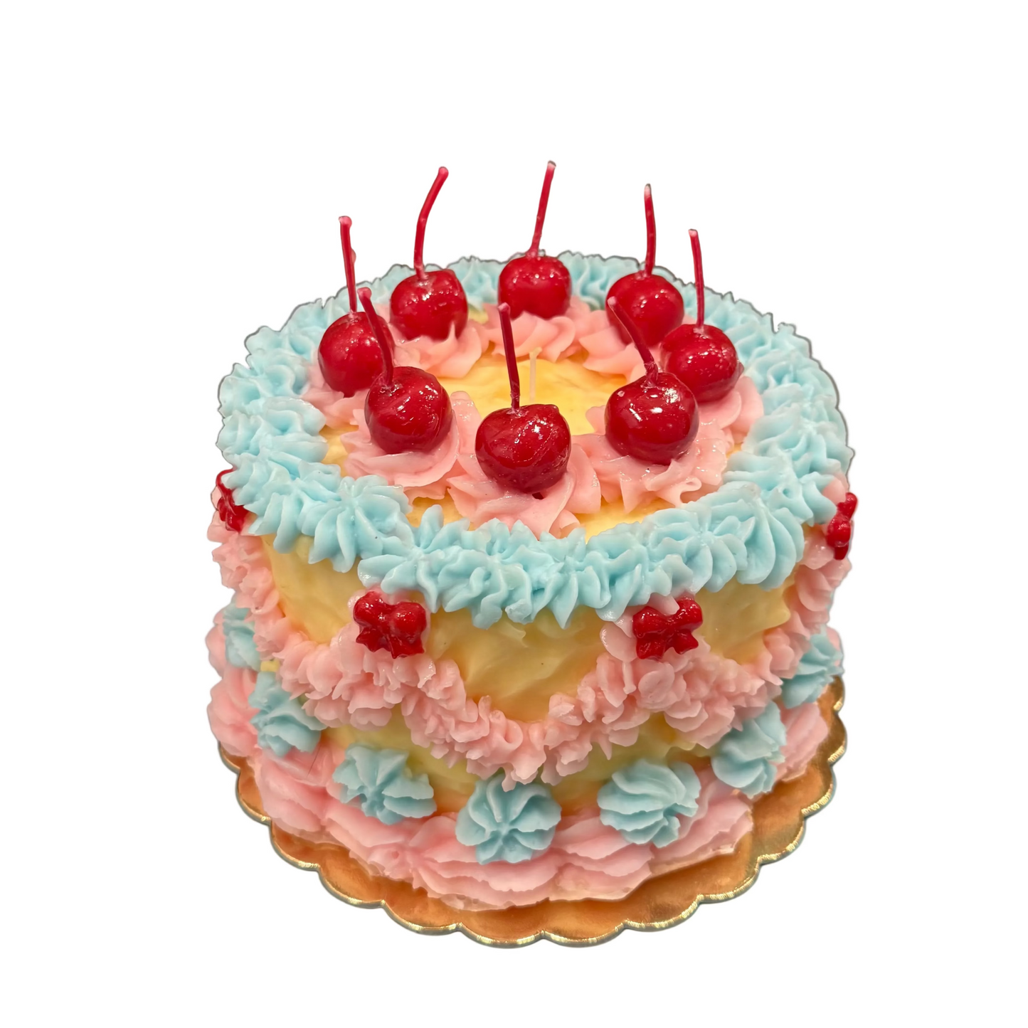 Two-tiered cake with pink and blue frosting and cherries on a blue plate.