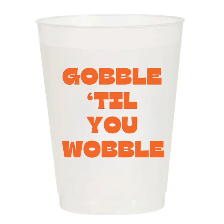 A white translucent plastic cup with bold orange text reading 'GOBBLE 'TIL YOU WOBBLE' on a plain white background.