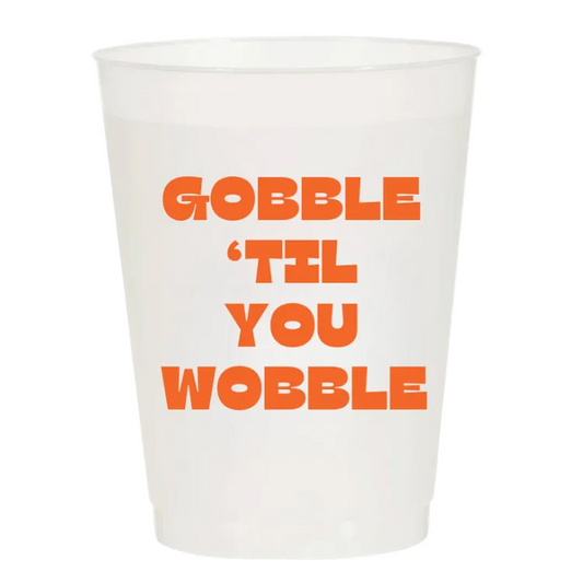 A white translucent plastic cup with bold orange text reading 'GOBBLE 'TIL YOU WOBBLE' on a plain white background.