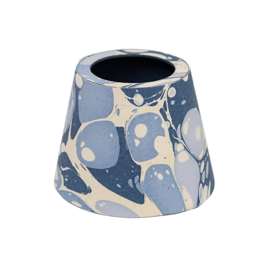A small conical ceramic vase with a blue and cream marbled pattern, shown against a plain white background.