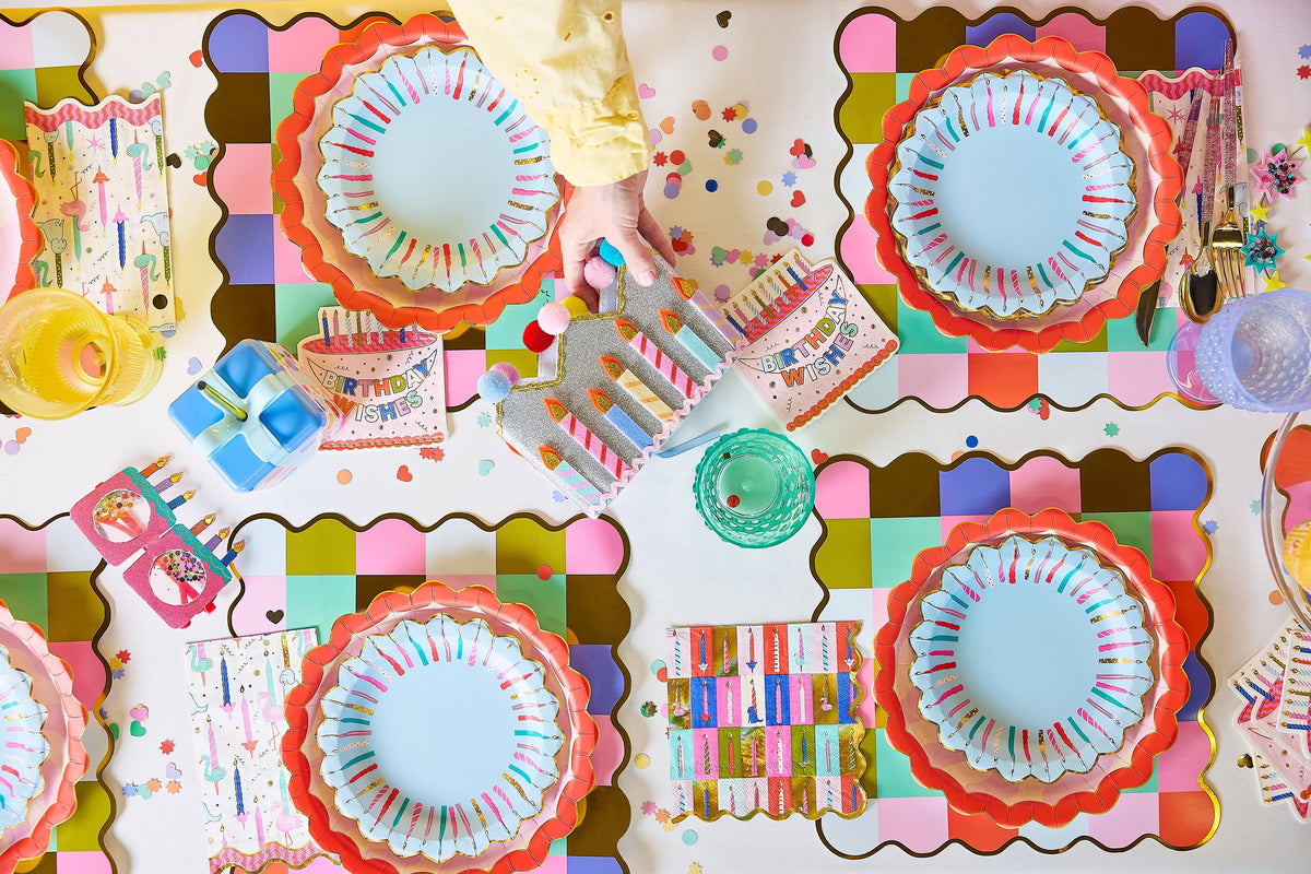Colorful party decorations with paper plates and balloons on a table.