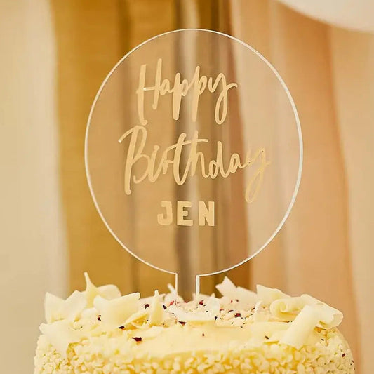 Clear acrylic cake topper with 'Happy Birthday Jen' on a decorated cake.