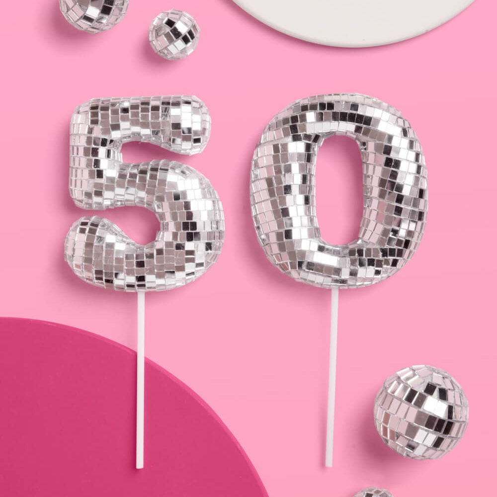 Silver disco ball numbers '50' on sticks against a pink background