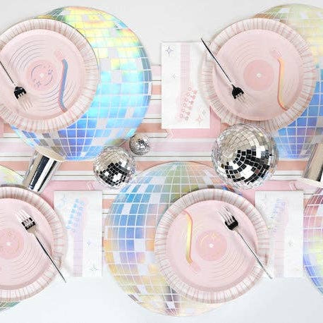 Iridescent plates with silver party hats and disco balls on a white background