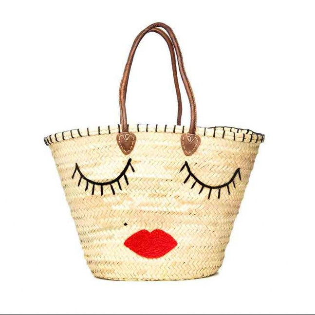 Woven bag with face design featuring eyes, nose, and red lips on a white background
