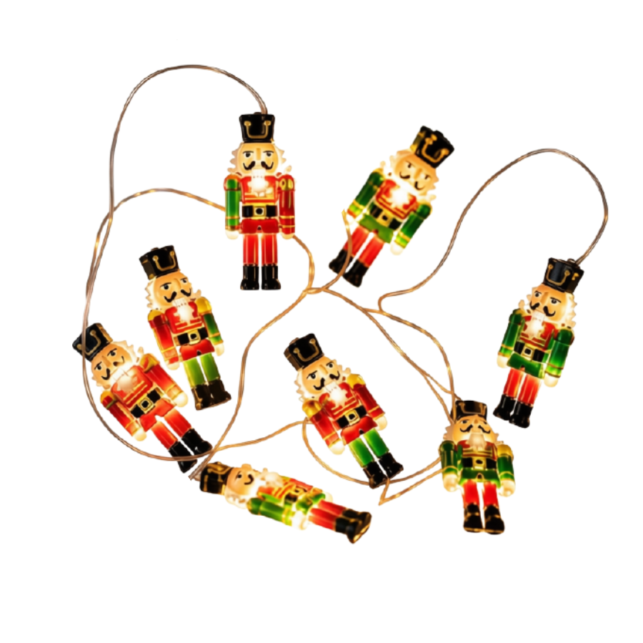 A string of nutcracker-shaped Christmas lights on a white background. The lights are illuminated with warm white glow, showing red, green, black, and gold details, with some lights turned off.