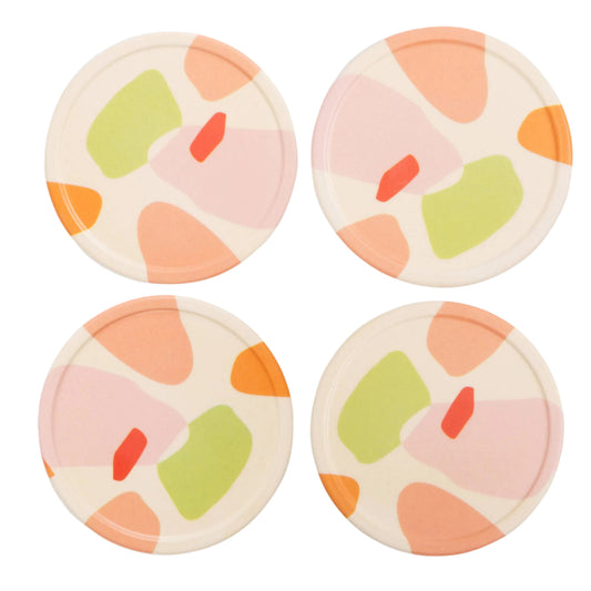 Four round coasters with colorful abstract patterns on a white background
