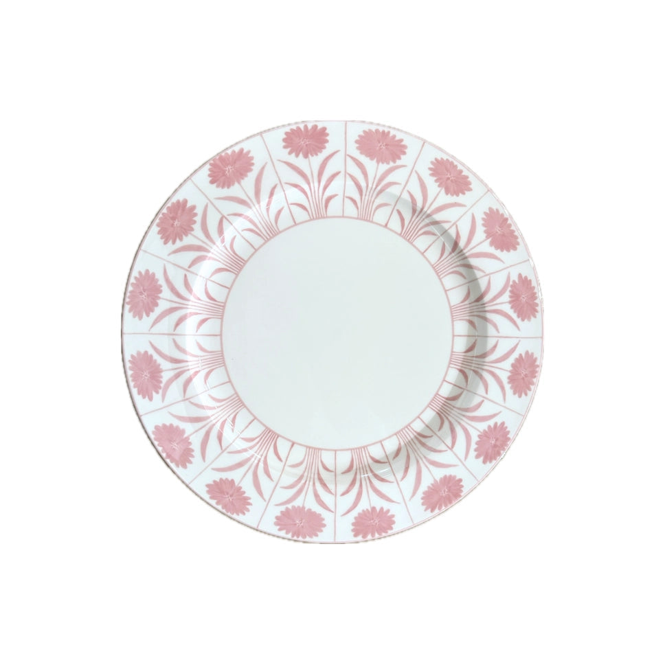 A round white ceramic plate featuring a delicate pink floral border pattern, centered on a solid white background.