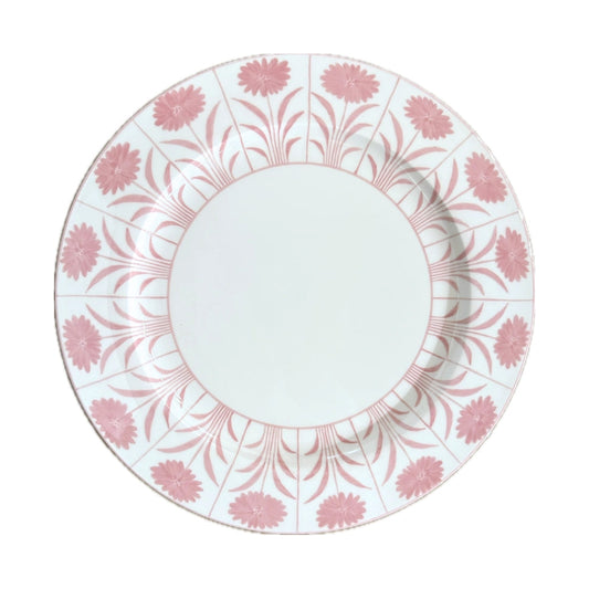 A round white ceramic plate featuring a delicate pink floral pattern printed along its rim, shown against a plain white background.