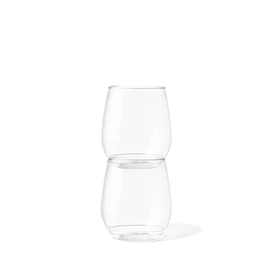 Two clear stemless wine glasses stacked vertically with their rims touching, shown on a clean white background.