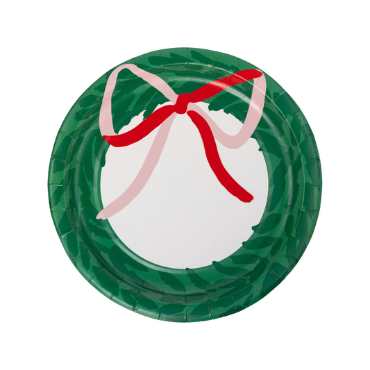 A round paper plate decorated with a green holly wreath pattern and a red and light pink ribbon bow, shown on a plain white background.